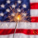 Sparkler burning in front of an American flag.