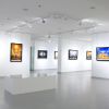 A modern art gallery with framed photographs hanging on white walls.