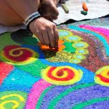 Person creating colorful street art with chalk.